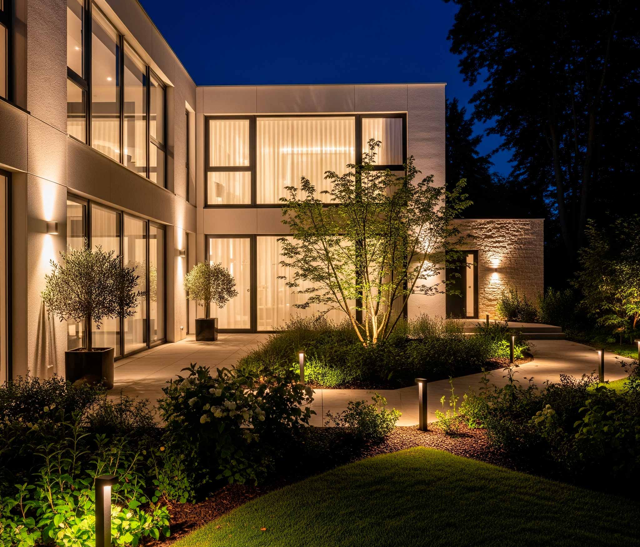 Jardín y fachada de una casa moderna iluminados con luces LED de exterior